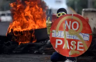 Un-manifestante-se-escuda-con-un-cartel-durante-una-protesta-en-Cali-contra-la-p