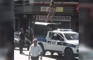 Mujer arriba del techo de un m�vil policial