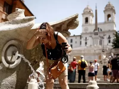 Una mujer se refresca en la Fontana della Barcaccia en la Plaza de Espaa durant