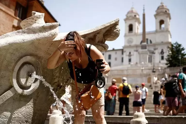 Una mujer se refresca en la Fontana della Barcaccia en la Plaza de Espaa durante una ola de calor en toda Italia REUTERS/Guglielmo Mangiapane