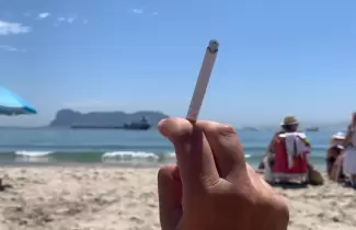 Persona fumando en la playa