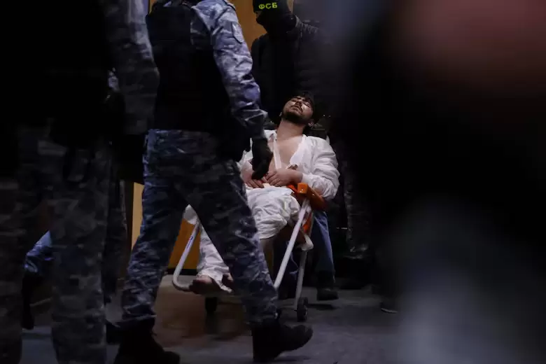Un hombre sospechoso de participar en el ataque a una sala de conciertos que dej 137 personas muertas es escoltado por agentes rusos