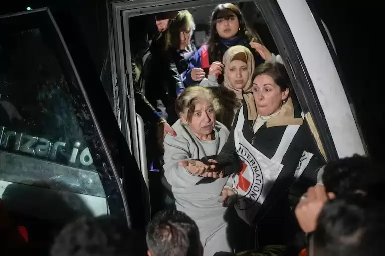 Prisioneras palestinas descienden de un autobús tras ser liberadas de una prisión israelí, en la ciudad cisjordana de Beitunia, la madrugada del lunes