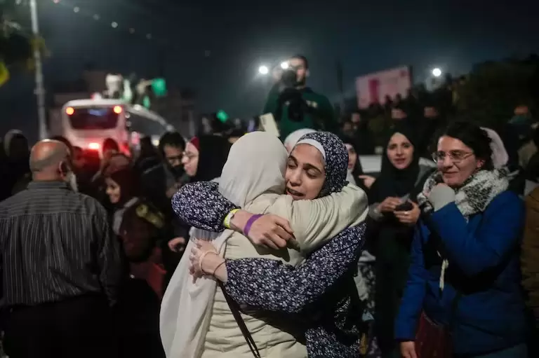 Una prisionera palestina, en el centro a la izquierda, es recibida después de descender de un autobús tras su liberación de una prisión israelí