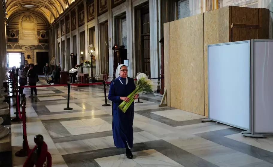 Una monja lleva flores junto dentro de la Basílica Papal de Santa María la Mayor (Santa Maria Maggiore)
