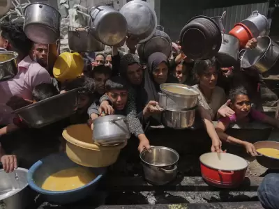 Palestinos luchan por conseguir alimentos donados en una cocina comunitaria en Jabalia, al norte de la Franja de Gaza, el lunes 19 de mayo de 2025