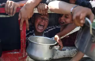 Palestinos esperan recibir comida de un comedor social, en medio de una crisis de hambre, en la ciudad de Gaza. REUTERS/Mahmoud Issa