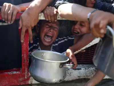 Palestinos esperan recibir comida de un comedor social, en medio de una crisis de hambre, en la ciudad de Gaza. REUTERS/Mahmoud Issa