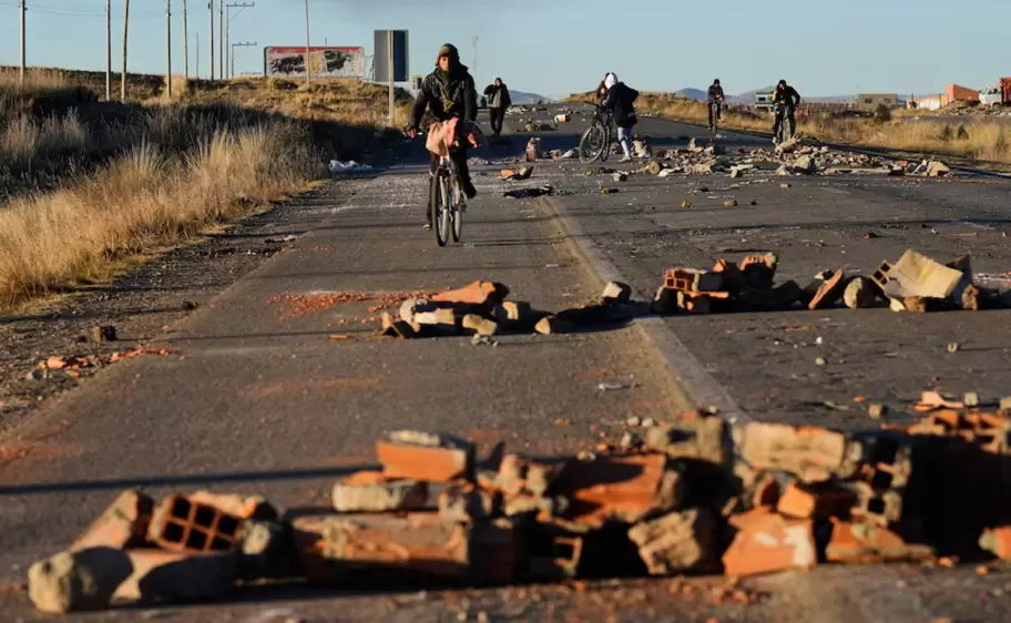 Varias personas rodean las barricadas levantadas por los manifestantes en la carretera que conecta La Paz con Oruro, cerca de El Alto, Bolivia